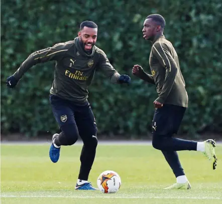  ?? — Reuters ?? Calm before the storm: Arsenal’s Alexandre Lacazette (left) in action during a training session at the Arsenal Training Centre in St Albans yesterday.