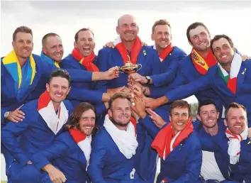  ?? Reuters ?? Team Europe captain Thomas Bjorn and his team pose with the trophy after winning the Ryder Cup at Le Golf National, Guyancourt, on Sunday.