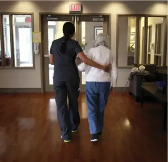  ?? MARTA IWANEK/TORONTO STAR ?? A staff member assists a resident at the Alzheimer Centre of Excellence near Bathurst St. and Finch Ave. The 44-bed care home currently has 20 residents, outnumberi­ng its staff members.