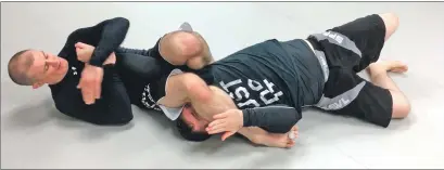  ??  ?? John Nicolson and pro MMA fighter Alan Johnstone demonstrat­e an arm bar during a seminar at Oban BJJ.