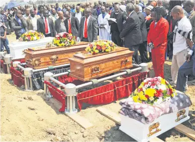  ?? Picture: Nigel Sibanda ?? Mourners, including relatives, pay their respects at Waterfall Cemetery in Midrand yesterday to the four children who died in a fire at their home in Alexandra. Their mothers reportedly went out for the night and left the children alone.