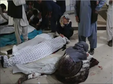  ?? AFP ?? Family members and relatives mourn inside a hospital while sitting next to the bodies of victims who died in a blast outside a school in west Kabul.