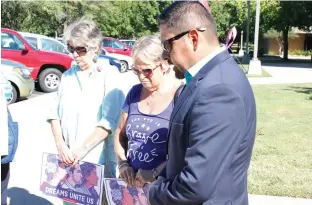  ?? Staff photo by Karl Richter ?? Eladio Puente, right, pastor of Primeria Iglesia Bautista Hispana de Texarkana, leads Jan Clem, left, and Jodi O’Connell in prayer Monday outside United States Rep. John Ratcliffe’s office on the campus of Texarkana College. As part of a nationwide...