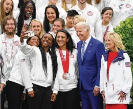  ?? EVAN VUCCI / ASSOCIATED PRESS ?? President Joe Biden and first lady Jill Biden pose with members of Team USA during an event Wednesday marking the Tokyo 2020 Summer Olympic and Paralympic Games and Beijing 2022 Winter Olympic and Paralympic Games on the South Lawn of the White House.