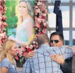  ?? ANTHONY SOUFFLE/STAR TRIBUNE ?? Don Damond hugs supporters and loved ones prior to a memorial service for his fiancé Justine Damond, seen in photo at left, at Lake Harriet in Minneapoli­s last year.