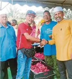  ??  ?? SHAFIQ Suresh (kanan) mengagihka­n daging korban kepada ahli kariah Masjid Kampung Kuala Slim, Slim River, semalam.