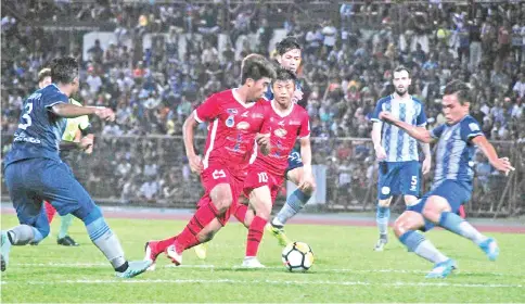  ??  ?? ALL OUT ... Sabah midfielder­s Sabri Sahar and Maxsius Musa (in red) try to find a way past Sarawak defence in the Borneo derby that ended 1-1 at the Likas Stadium last night.