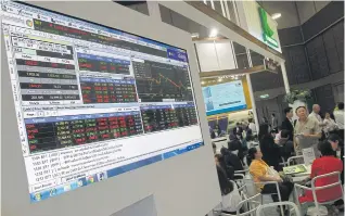  ??  ?? An electronic board diplays share prices at the recent SET in the City fair. Kasikorn Securities has a 12-month forward target for the SET index of 1,766 points and an expected 12% total return.