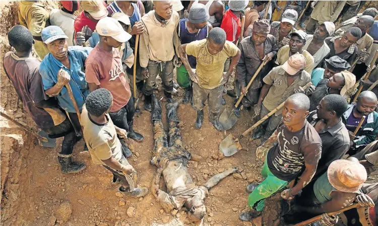  ??  ?? MAN DOWN: Miners uncover the body of Zawadi Kambale, who was killed when a rock face collapsed at Musia gold mine, North Kivu province, in the Democratic Republic of Congo