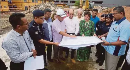  ?? [FOTO MOHD YUSNI ARIFFIN/BH] ?? Zulhasnan (lima dari kiri) mendengar penerangan daripada Fauzi (empat dari kiri) ketika melawat tapak projek pembinaan Balai Polis Taman Setiawangs­a, semalam.