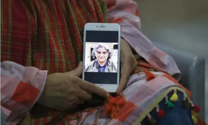 ??  ?? Kaneez Sughra displays a photograph of her husband, Matiullah Jan, on her mobile phone. Photograph: Anjum Naveed/AP