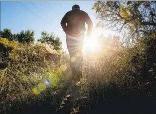  ?? Photograph­s by Isaac Hale For The Times ?? MERRELL sets off on one of his favorite hikes near his home just outside Vernal. He knows many will say his beliefs are a mask for pain, fear and doubt, but that hardly matters to him.