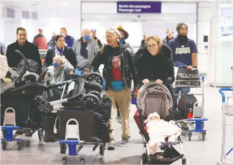  ?? CHRISTINNE MUSCHI/ REUTERS ?? Canadians flood through Montreal-Trudeau Internatio­nal Airport in Montreal on March 23 after being stranded in Morocco due to flight restrictio­ns imposed due to the COVID-19 pandemic. Nearly one million Canadians returned to Canada between March 14 and 20.