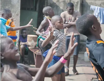  ?? REBECCA VASSIE/ THE ASSOCIATED PRESS ?? Children perform a traditiona­l courtship dance from eastern Uganda as part of a platform for changing attitudes among youth using dance, drama and popular hip hop music in the Kamwokya slum of Kampala, Uganda, to mark World AIDS Day.