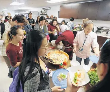  ?? Photograph­s by Allen J. Schaben Los Angeles Times ?? STUDENTS LINE UP for Vietnamese spring rolls at the grand opening of UC Irvine’s new food pantry. The 1,800-square-foot facility stocks fresh produce, canned and dried goods, and refrigerat­ed and frozen food.