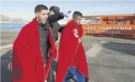  ??  ?? Un policía indica a dos inmigrante­s a donde dirigirse, ayer en Cartagena.