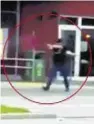  ??  ?? Video image shows one of the gunmen dressed in black shooting people outside a McDonald's