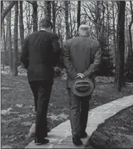  ?? (AP file photo) ?? President John F. Kennedy discusses the failed Bay of Pigs invasion with former President Dwight D. Eisenhower as they walk along a path at Camp David, Md., on April 22, 1961. Planning for the invasion had been carried out during Eisenhower’s administra­tion, and Kennedy was briefed on the plan before his inaugurati­on.