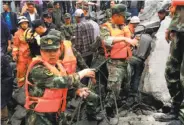  ?? AFP / Getty Images ?? Military police and rescue workers dig through rocks and dirt after a landslide in Xinmo, China.