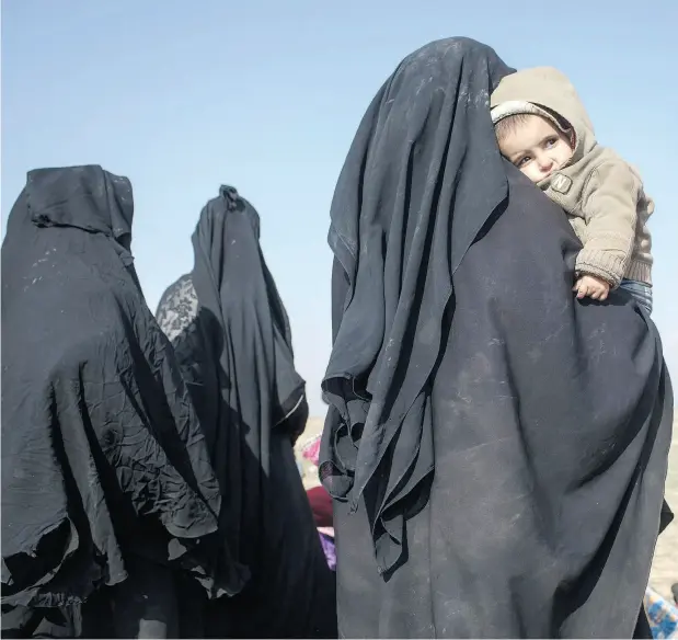  ?? CHRIS MCGRATH / GETTY IMAGES ?? Civilians who have fled fighting in Baghouz, the last village held by ISIL, wait to board trucks on Saturday after being screened by members of the Syrian Democratic Forces. Two Canadian women and their children are among those being held after fleeting the caliphate’s last enclave.