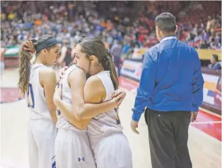  ?? JUAN ANTONIO LABRECHE/FOR THE NEW MEXICAN ?? Maricela MacAuley, left, and Alexandria Sandoval of Peñasco embrace after losing the girls Class 2A championsh­ip on Friday to Fort Sumner/House, 49-38.