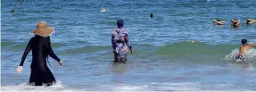  ?? PHOTO: REUTERS ?? Covered . . . Women wearing fullbody burkini swimsuits enjoy the sea at a beach in La Marsa, near Tunis.
