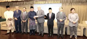  ?? ?? Awang Tengah (fourth right) hands over the annual donation from STIDC to a representa­tive of the recipients, witnessed by Zainal (third left), Naroden (third right) and Hashim (second right).