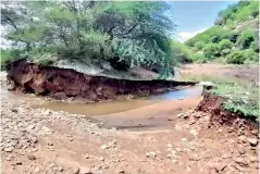  ??  ?? Water flowing out of an irrigation tank that suffered a breach near Ponnapalli village in Ambur region on Monday night