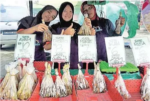  ??  ?? SUZAINEH (tengah) bersama rakannya menjual pelbagai jenis sate.