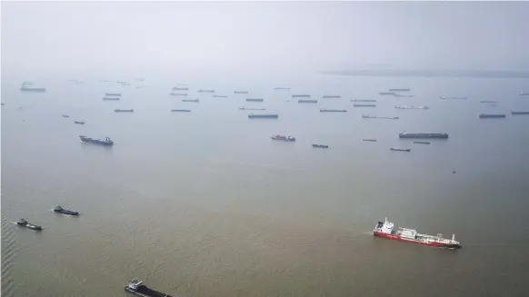  ?? Bloomberg ?? Bulk carrier ships on the Yangtze River. From January 1, 2020, vessels around the world will need to use fuels containing less sulphur under the new rules