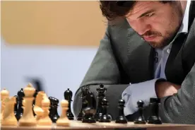  ?? Photograph: Yoshua Arias/EPA ?? Magnus Carlsen studies the board during game 11 of the World Chess Championsh­ip.