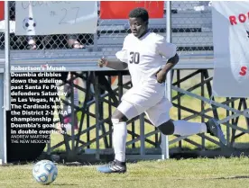 ?? ANDREW MARTINEZ THE NEW MEXICAN ?? Robertson’s Musah Doumbia dribbles down the sideline past Santa Fe Prep defenders Saturday in Las Vegas, N.M. The Cardinals won the District 2-1A/4A championsh­ip on Doumbia’s goal late in double overtime.