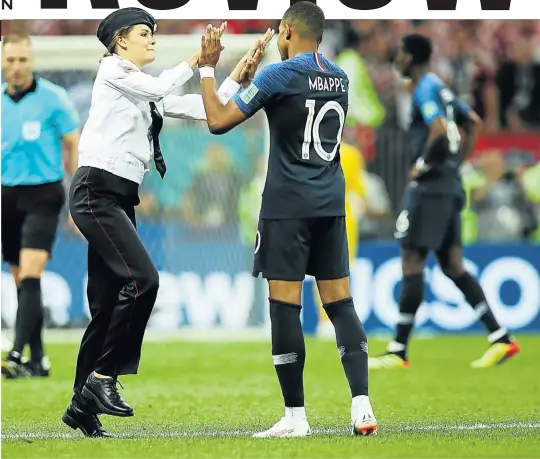  ?? Picture: Ian MacNicol/Getty Images ?? Olya Kurachyova high-fives Kylian Mbappe during a pitch invasion at the World Cup 2018 final.