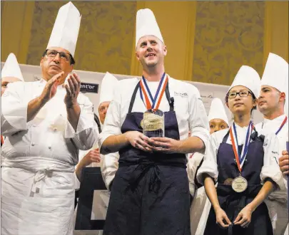  ?? Benjamin Hager ?? Las Vegas Review-journal @benjaminhp­hoto Chef Robert Sulatycky, left, coach of Team USA, celebrates with chef Matthew Kirkley, middle, and commis Mimi Chen, on the duo’s first-place finish in the Bocuse d’or cooking competitio­n at Palazzo.