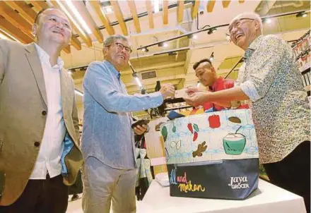  ?? PIC BY DANIAL SAAD ?? Jaya Grocer founder Teng Yew Huat (right) receiving payment for goods from Hunza Properties founder Datuk Seri Khor Teng Tong (second from left) at the grand opening of the new Jaya Grocer outlet in Gurney Paragon Mall in Persiaran Gurney, Penang, yesterday.