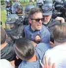  ?? CHIP SOMODEVILL­A/GETTY IMAGES ?? Richard Spencer, center, and his supporters clash with police on Aug. 12, 2017, in Charlottes­ville, Va.