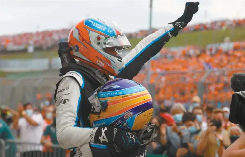  ?? FLORION GOGA ASSOCIATED PRESS ?? L’ancien champion du monde Fernando Alonso a soulevé son coéquiper chez Alpine Estrban Ocon lorsqu’il l’a félicité pour sa première victoire en Formule 1.