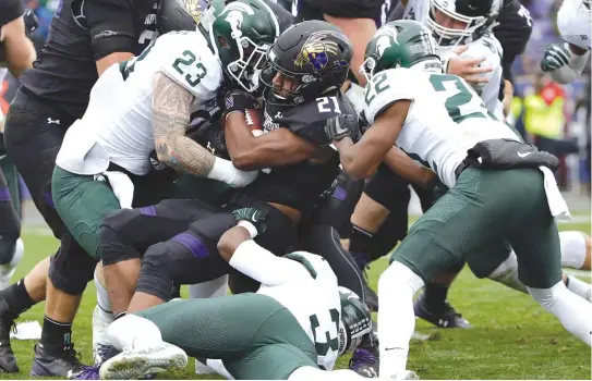  ?? | AP ?? Northweste­rn running back Justin Jackson has been tough for defenders to bring down. He tied the school’s all- time touchdown record Saturday against Michigan State.