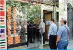  ?? —Reuters ?? TEHRAN: People watch the rial rates at an exchange in Tehran. Iranian currency’s fall has not only made life more expensive, it may also test Iran’s ability to prop up an economy battered by crippling US sanctions and the new coronaviru­s.