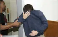  ?? THE ASSOCIATED PRESS ?? A 19-year-old dual U.S.-Israeli citizen covers his face as he is brought to court in Rishon Lezion, Israel, on Thursday.