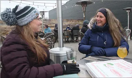  ?? DAVE ANGELL — FOR THE MACOMB DAILY ?? Cindy Nicholson and Stacy Gekiere were among those willing to brave the elements to share a beer and a pizza. Copper Hop has a food truck on weekends.