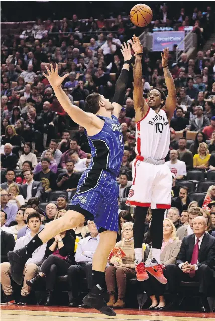  ?? — THE CANADIAN PRESS ?? Toronto Raptors guard DeMar DeRozan shoots over Orlando Magic centre Nikola Vucevic Monday in Toronto. The Raptors scored 73 first-half points en route to a 131-112 win.