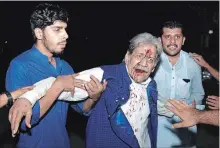  ?? K.M. CHAUDARY THE ASSOCIATED PRESS ?? People hold an injured supporter of former prime minister Nawaz Sharif after a clash with police in Lahore, Pakistan, on Friday.