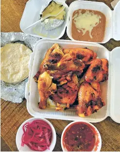  ?? PHOTOS BY KRISTEN COX ROBY/FOR THE NEW MEXICAN ?? El Rey del Pollo’s family feast features a whole chicken cut into pieces and served with tortillas, one baked potato with cheese, a small container of refried beans and a generous carton of pink pickled onions.