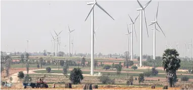  ?? PANUMAS SANGUANWON­G ?? A wind turbine farm rises above cassava plantation­s in Dan Khun Thot district, Nakhon Ratchasima. The Agricultur­al Land Reform Office has ruled that wind farm projects can be developed on Sor Por Kor land.