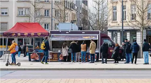  ?? Fotos: Christophe Olinger ?? Beim Hähnchenst­and stehen hungrige Menschen Schlange.