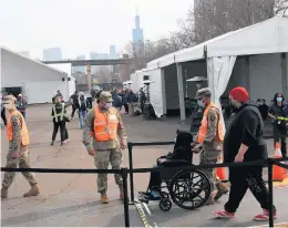  ?? ANTONIO PEREZ/CHICAGO TRIBUNE ?? People are assisted by members of the National Guard as they enter the United Center mass vaccinatio­n site on Tuesday.