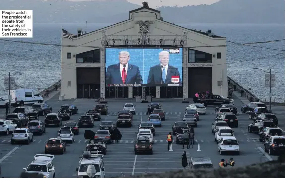  ??  ?? People watch the presidenti­al debate from the safety of their vehicles in San Francisco