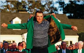 ?? AJC 2022 ?? Scottie Scheffler puts on the green jacket after winning the Masters at Augusta National Golf Club on April 10, 2022. Scheffler has won six titles in the past 13 months.