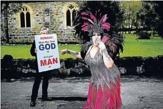  ?? /Alon Skuy ?? Lone voice: An antigay demonstrat­or is mocked by drag artist Betty Bangles at the Pink Loerie Mardi Gras in Knysna. The World Travel Market estimated the LGBT travel market was worth more than $211bn in 2016.